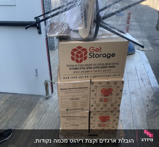 ארגזים על עגלה עם כיסאות עטופים בניילון
